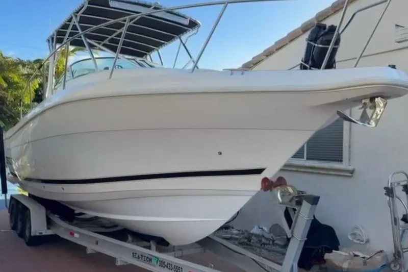 The Image of 2000 Century 3100 Walk-Around boat on trailer, white hull, outdoor setting. - 0