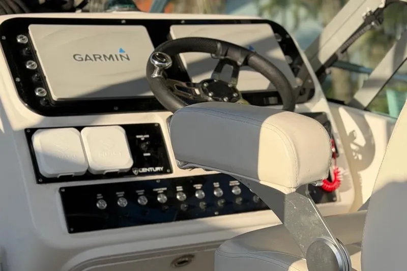 Slide: The Image of Century 3100 Walk-Around 2000 boat dashboard with Garmin navigation system and steering wheel. - 11