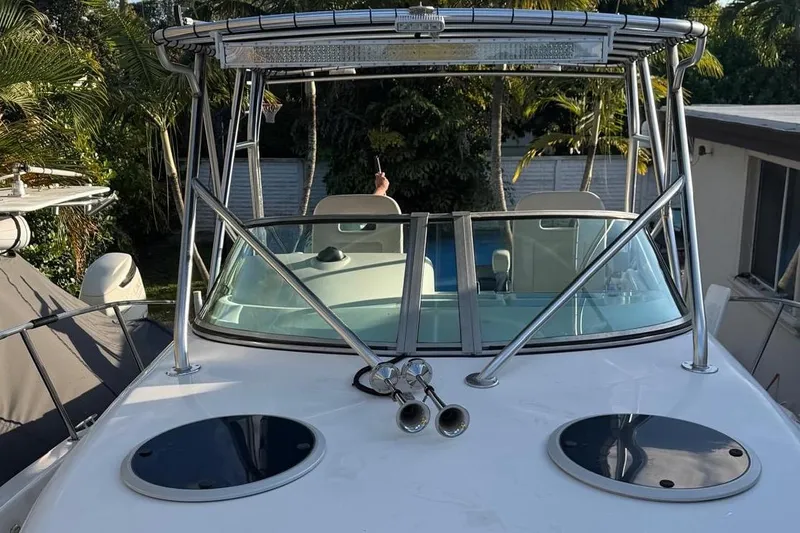 The Image of Century 3100 Walk-Around 2000 boat with T-top and dual horns, docked outdoors. - 14