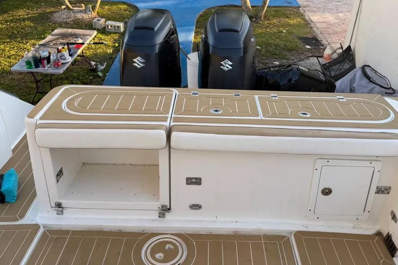 Slide: The Image of 2000 Century 3100 Walk-Around boat deck with storage compartments and dual Suzuki outboard motors. - 18