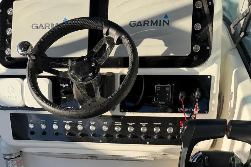Slide: The Image of Century 3100 Walk-Around 2000 boat dashboard with Garmin navigation and Suzuki controls. - 29