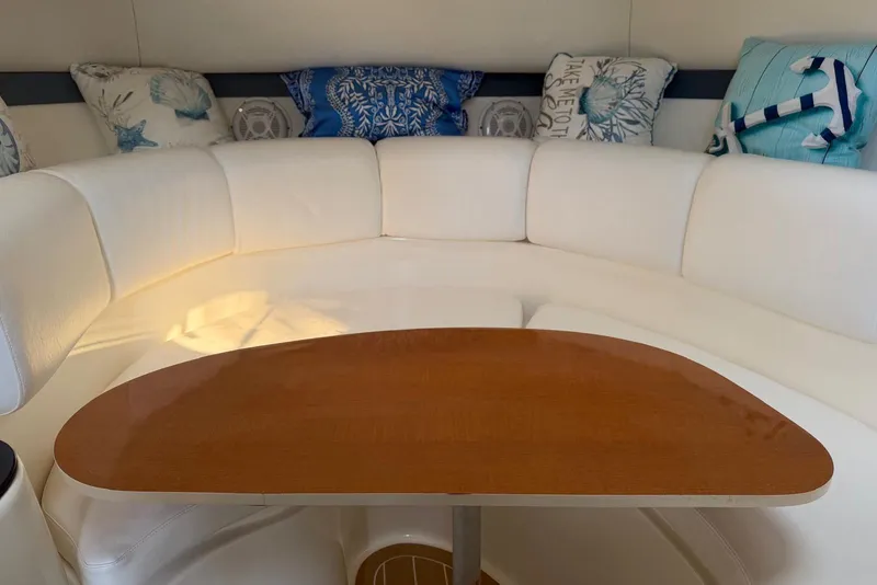 Slide: The Image of Interior of 2000 Century 3100 Walk-Around boat with white seating and wooden table. - 35