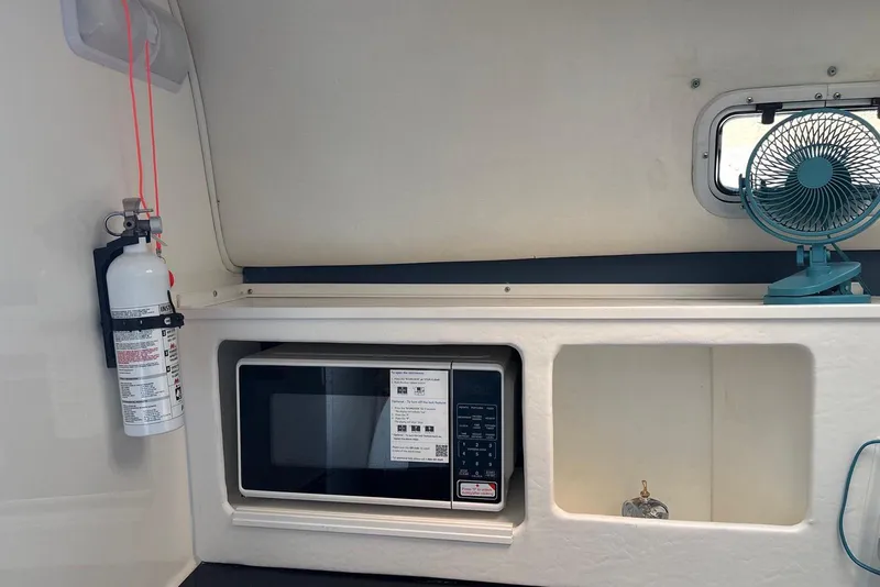 Slide: The Image of Interior of a 2000 Century 3100 Walk-Around boat with microwave, fan, and fire extinguisher. - 40