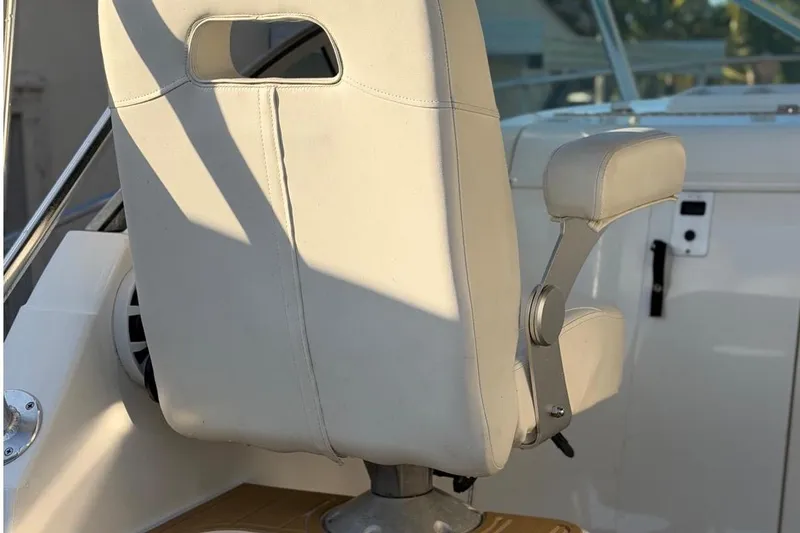 Slide: The Image of Century 3100 Walk-Around 2000 boat seat with armrest, white upholstery, and sunlight. - 9