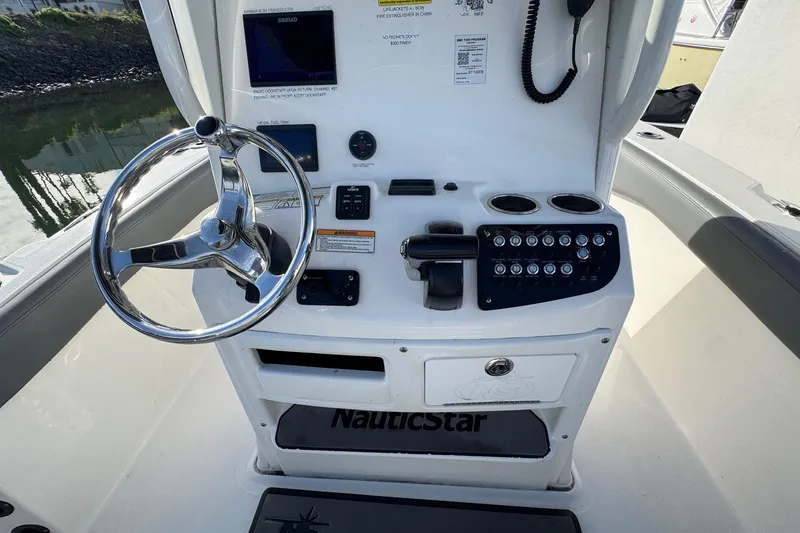 Slide: The Image of 2023 NauticStar 242L Offshore boat console with steering wheel and control panel. - 16