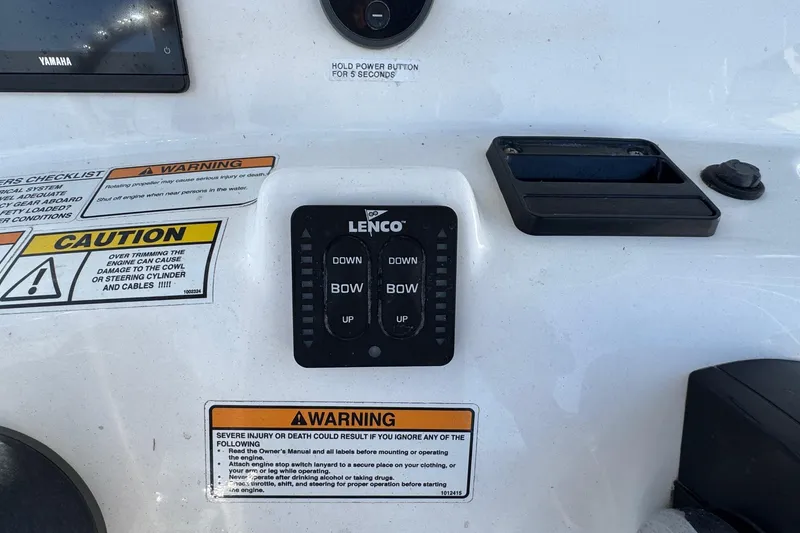 Slide: The Image of Control panel of 2023 NauticStar 242L Offshore boat with warning labels and Lenco trim tab switches. - 19