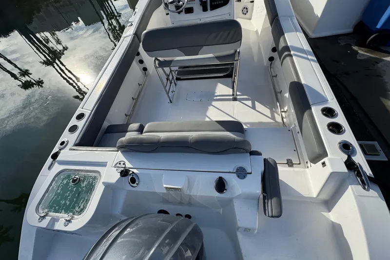 Slide: The Image of 2023 NauticStar 242L Offshore boat docked in marina with Yamaha engine. - 2