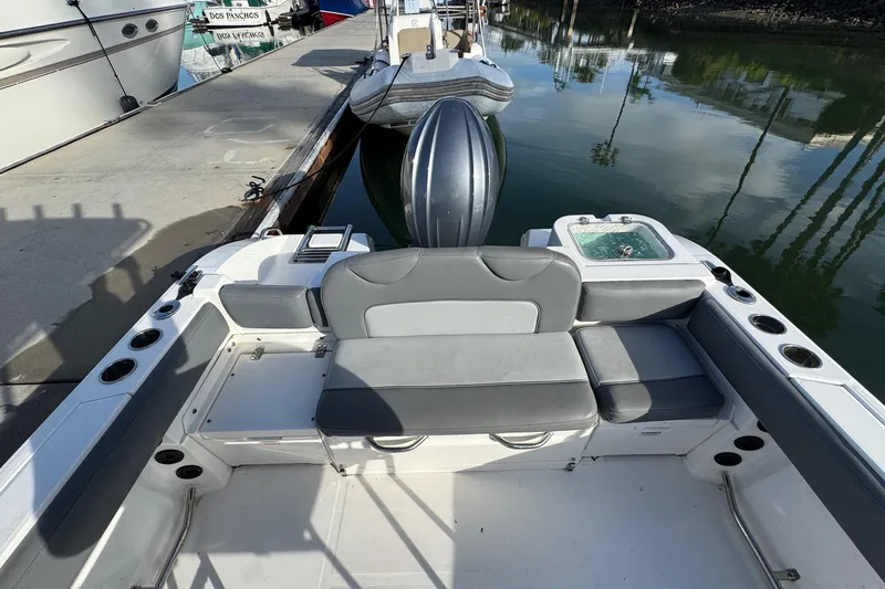 Slide: The Image of 2023 NauticStar 242L Offshore boat docked in a marina under clear blue skies. - 3