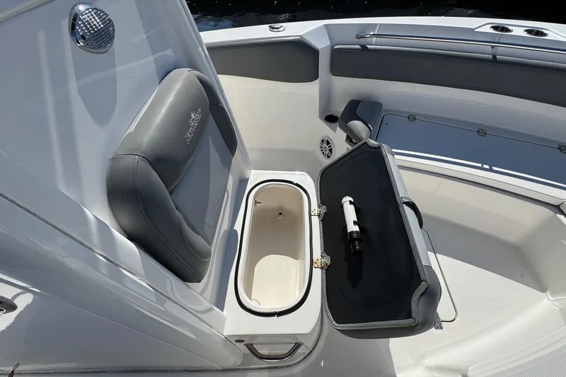 Slide: The Image of 2023 NauticStar 242L Offshore boat interior with open storage compartment and seating. - 32