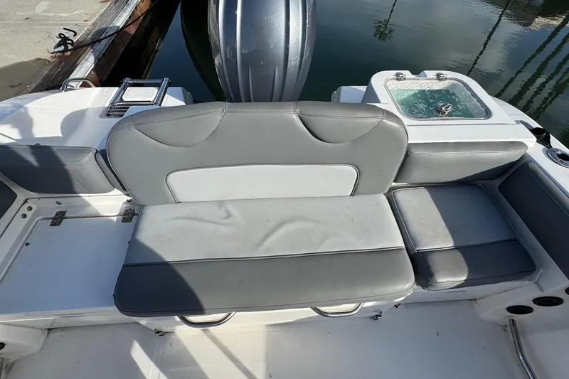 Slide: The Image of 2023 NauticStar 242L Offshore boat docked in a marina under clear blue skies. - 5