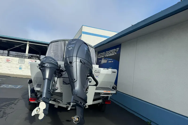 Slide: The Image of KingFisher 2025 Escape boat with dual Yamaha outboard motors, parked outside a building. - 8