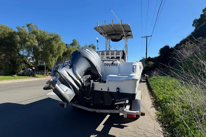 Slide: The Image of 2020 Wellcraft 222 Fisherman boat on trailer, parked roadside under clear blue sky. - 11