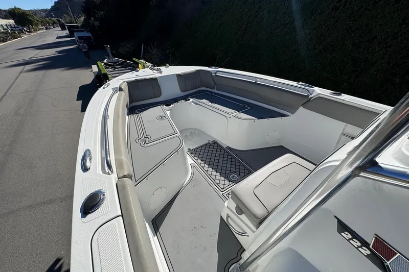 Slide: The Image of 2020 Wellcraft 222 Fisherman boat interior with seating and storage, parked on a sunny street. - 43