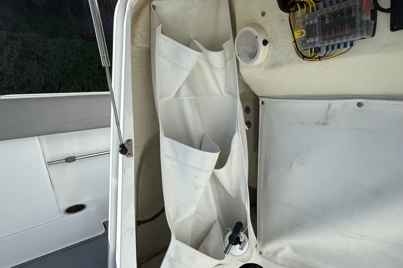 Slide: The Image of Interior view of a 2020 Wellcraft 222 Fisherman boat, featuring storage compartments and wiring. - 49