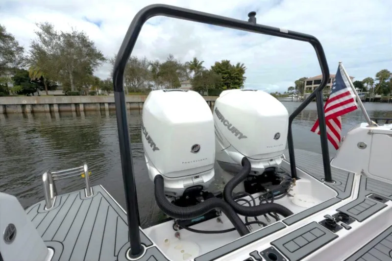 Slide: The Image of 2022 Axopar 37 Sun-Top with dual Mercury engines, docked by a waterfront. - 17