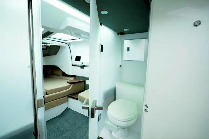 Slide: The Image of 2022 Axopar 37 Sun-Top interior with cabin and bathroom, featuring modern design and amenities. - 18