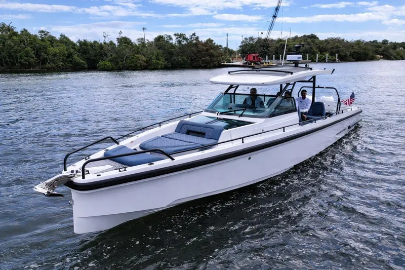 Slide: The Image of 2022 Axopar 37 Sun-Top boat cruising on a scenic waterway. - 3