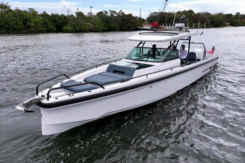 Slide: The Image of 2022 Axopar 37 Sun-Top boat cruising on a scenic waterway. - 6