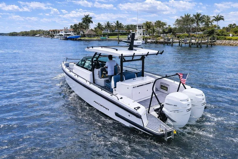 Slide: The Image of 2022 Axopar 37 Sun-Top boat cruising on a sunny day with twin Mercury engines. - 8