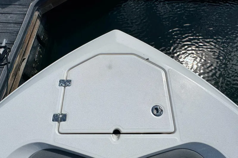 Slide: The Image of Bow of 2023 NauticStar 242L Offshore boat at dock, showing storage hatch. - 11