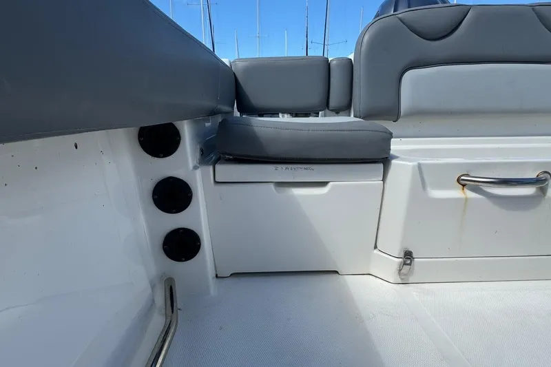 Slide: The Image of 2023 NauticStar 242L Offshore boat interior with gray seating and storage compartments. - 28