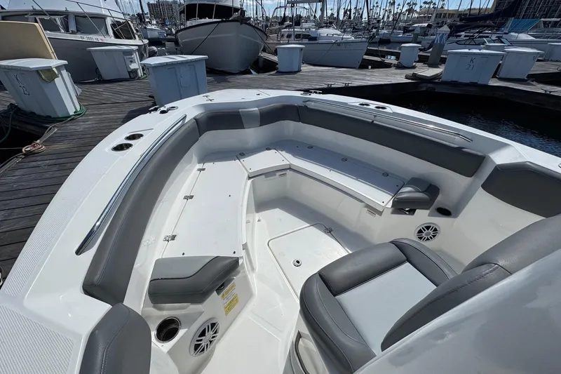 Slide: The Image of 2023 NauticStar 242L Offshore boat interior with seating, docked at marina. - 6