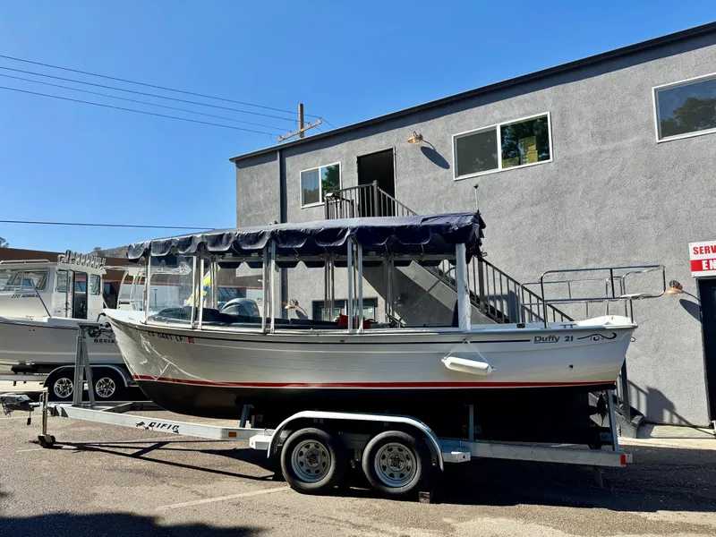 Slide: The Image of 2022 Duffy Sun Cruiser boat on trailer, parked outside a building. - 1