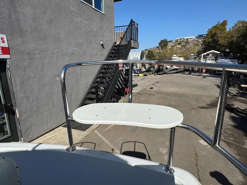 Slide: The Image of 2022 Duffy Sun Cruiser boat deck with railing near a dockside building. - 10