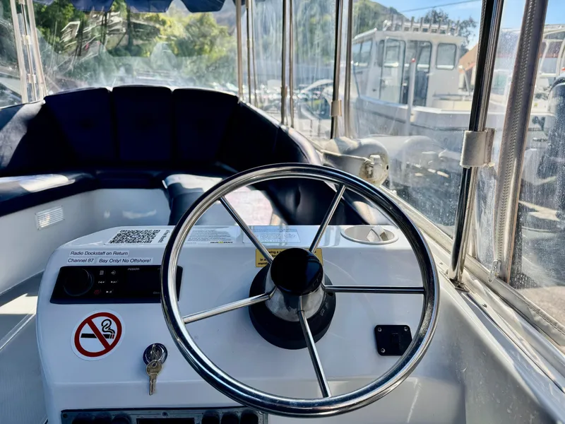 Slide: The Image of 2022 Duffy Sun Cruiser boat interior with steering wheel and seating area. - 15