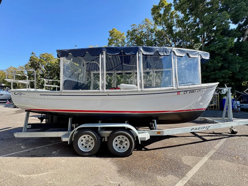 Slide: The Image of 2022 Duffy Sun Cruiser boat on trailer, parked outdoors with trees in background. - 4