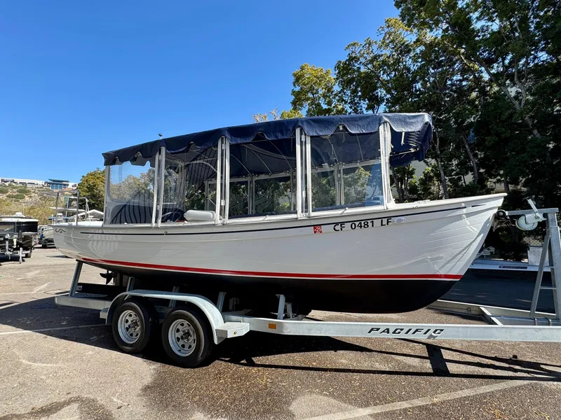 Slide: The Image of 2022 Duffy Sun Cruiser boat on trailer, parked outdoors under clear blue sky. - 5