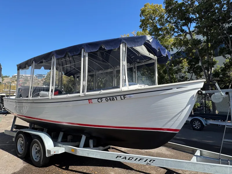 Slide: The Image of 2022 Duffy Sun Cruiser boat on trailer, parked outdoors with trees in background. - 6
