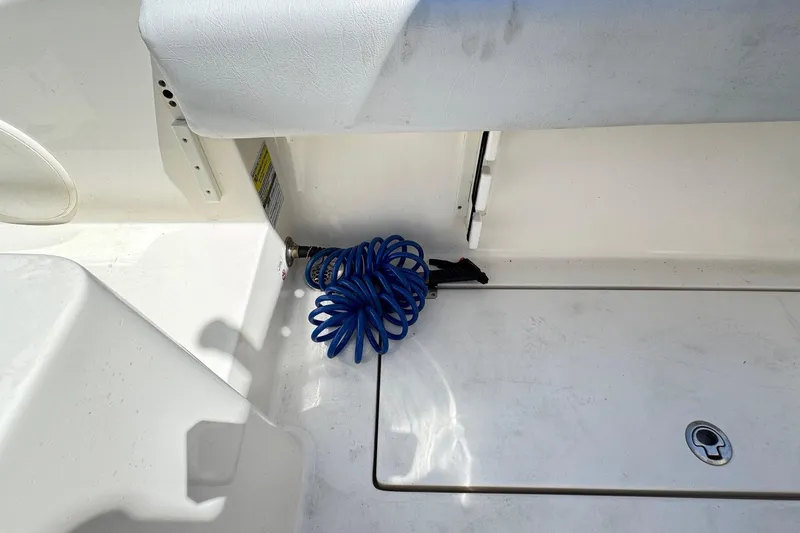 Slide: The Image of 2022 Cobia 237 Center Console boat deck with coiled blue hose. - 15