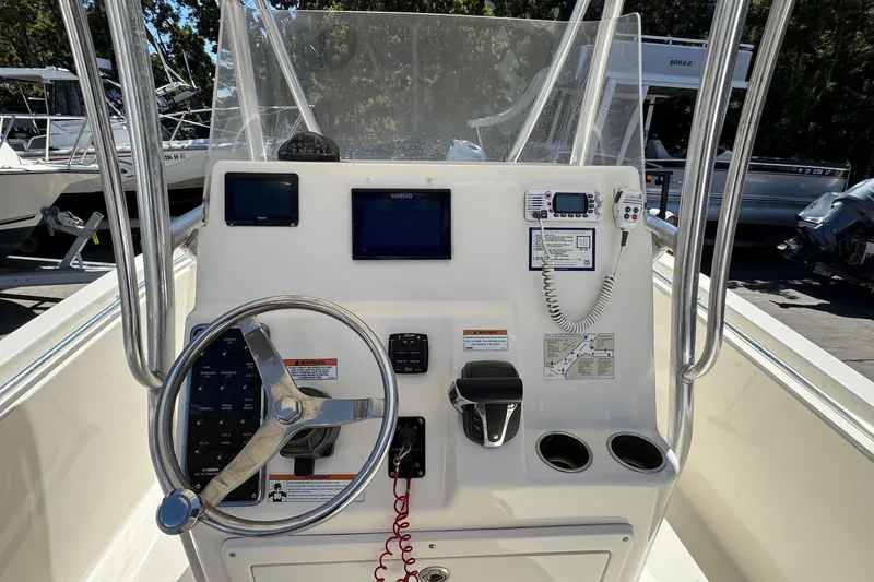 Slide: The Image of 2022 Cobia 237 Center Console boat dashboard with steering wheel and navigation equipment. - 20