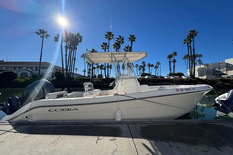 Slide: The Image of 2022 Cobia 237 Center Console boat docked under clear blue sky. - 7