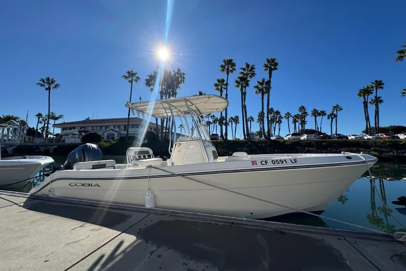 Slide: The Image of 2022 Cobia 237 Center Console boat docked under clear blue sky. - 8