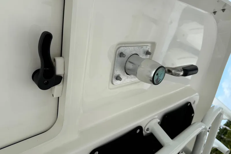 Slide: The Image of 2020 Boston Whaler 330 Outrage boat detail, featuring a latch and handle on a white surface. - 21