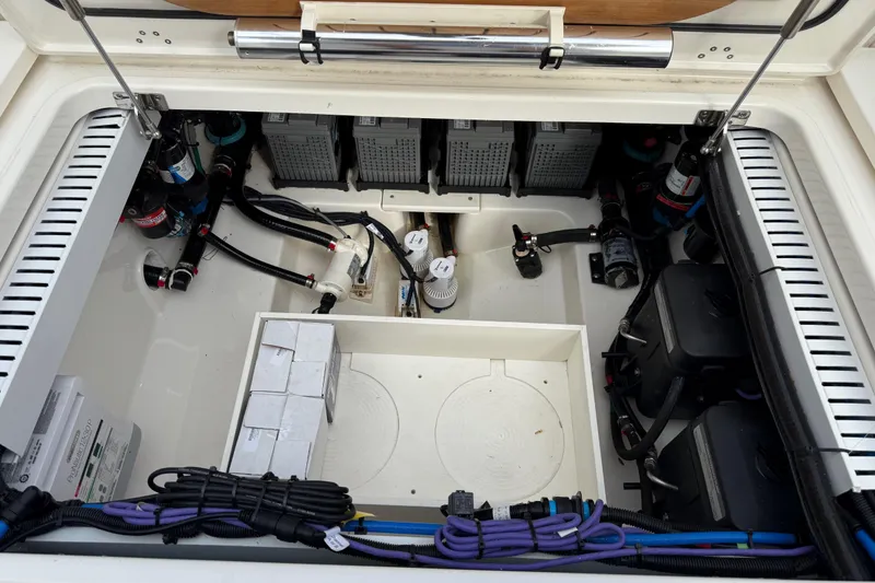 Slide: The Image of 2020 Boston Whaler 330 Outrage engine compartment with batteries and wiring. - 27