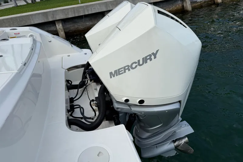 Slide: The Image of 2020 Boston Whaler 330 Outrage with dual Mercury outboard engines docked by water. - 9