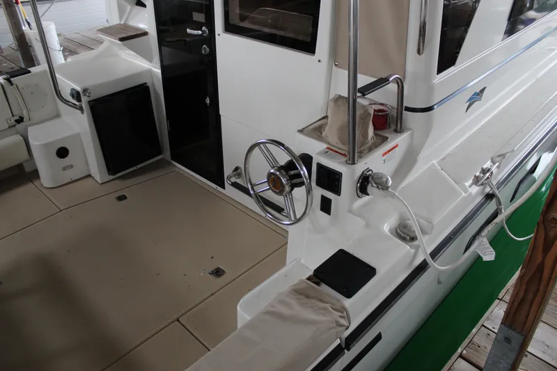 Slide: The Image of 2016 Cutwater 30 Command Bridge boat interior with steering wheel and deck details. - 14