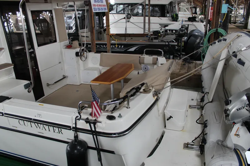 Slide: The Image of 2016 Cutwater 30 Command Bridge boat docked, featuring a spacious deck and seating area. - 19
