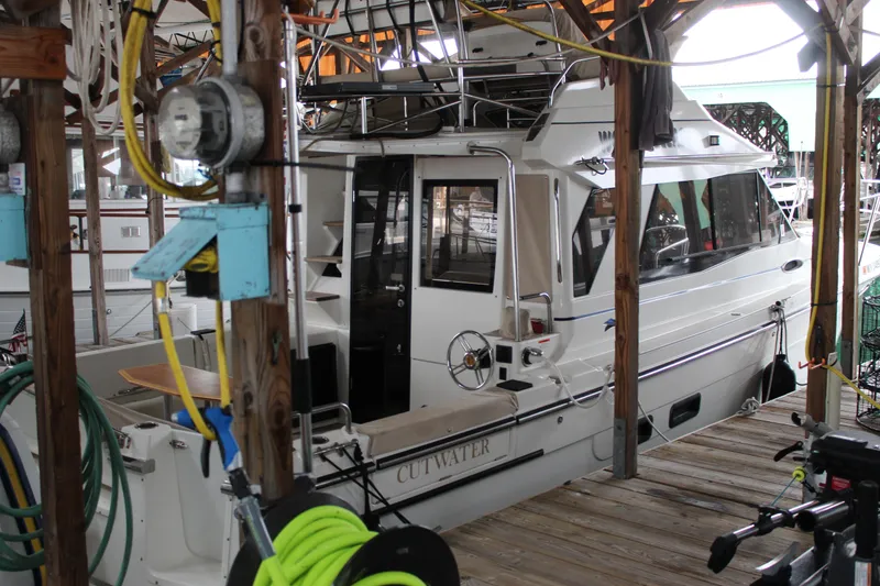 Slide: The Image of 2016 Cutwater 30 Command Bridge docked in a marina, surrounded by boating equipment. - 2
