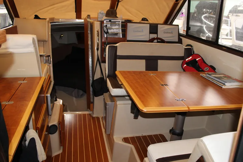 Slide: The Image of Interior of 2016 Cutwater 30 Command Bridge with wood accents and seating area. - 6