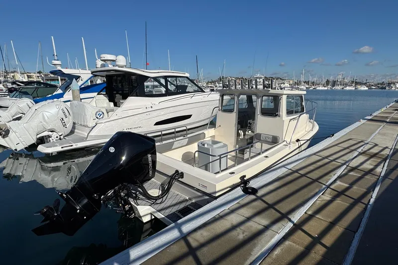 Slide: The Image of 2023 Defiance Admiral 220 EX boat docked at a marina under clear blue skies. - 14