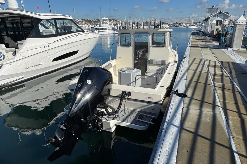 Slide: The Image of 2023 Defiance Admiral 220 EX boat docked at marina, sunny day. - 15