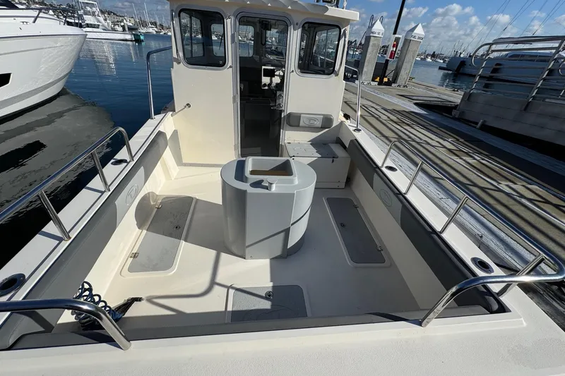 Slide: The Image of 2023 Defiance Admiral 220 EX boat docked at marina, spacious deck, clear skies. - 18