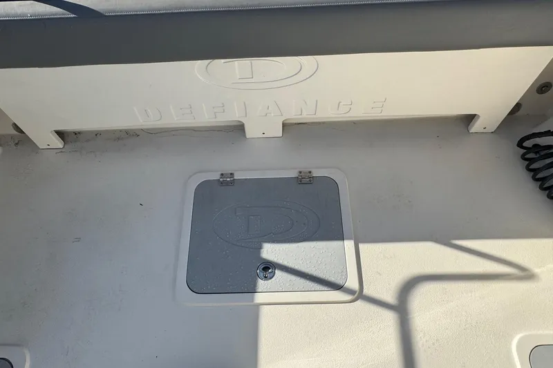 Slide: The Image of 2023 Defiance Admiral 220 EX boat deck with storage hatch and branding. - 26