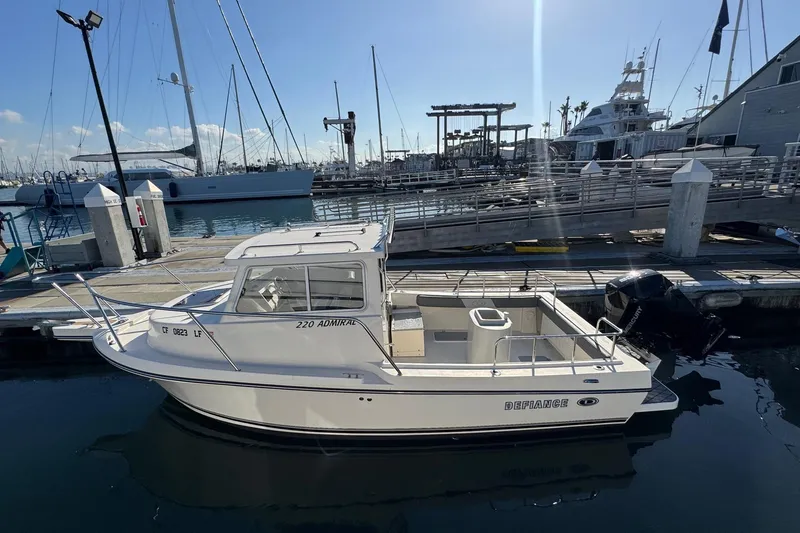 Slide: The Image of 2023 Defiance Admiral 220 EX boat docked at marina under clear sky. - 3
