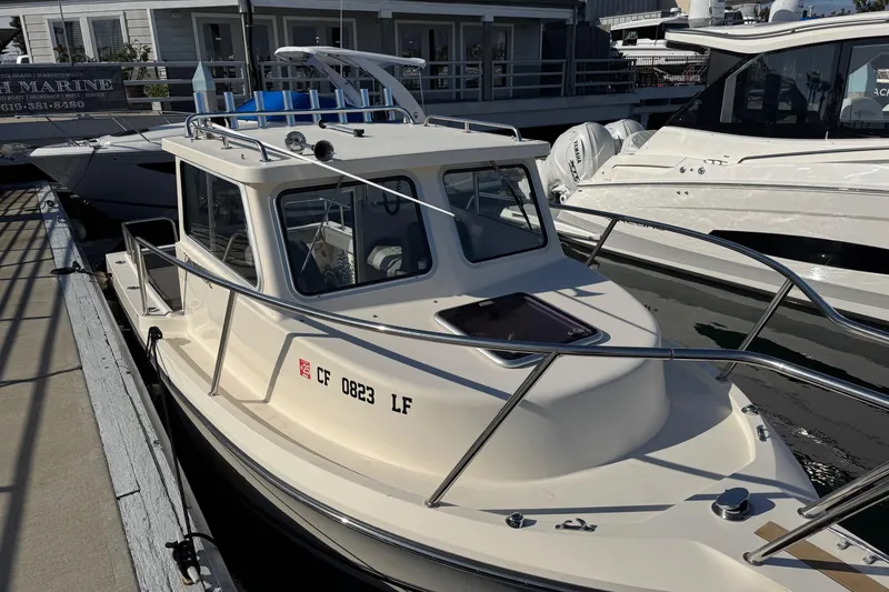 Slide: The Image of 2023 Defiance Admiral 220 EX boat docked at marina, showcasing sleek design and sturdy build. - 49