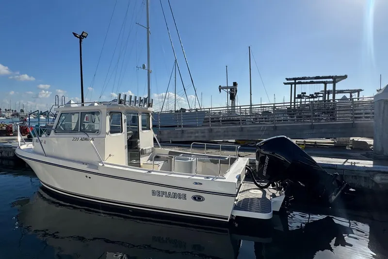 Slide: The Image of 2023 Defiance Admiral 220 EX boat docked at marina under clear blue sky. - 6
